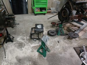 “David Brown tractor split at the bell housing for clutch replacement, front and rear sections supported on stands.”